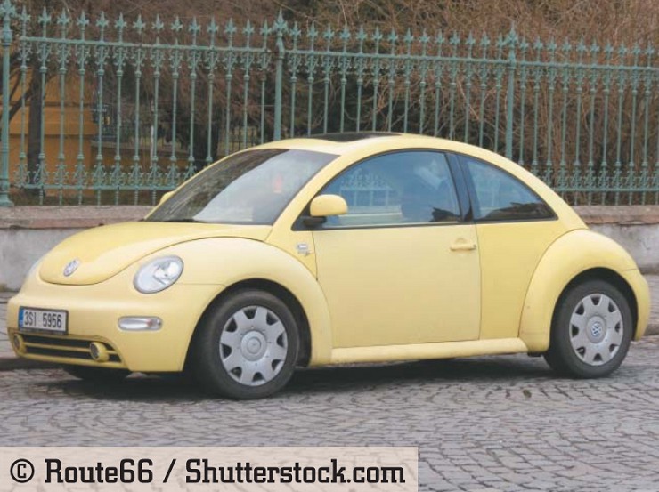 Желтый автомобиль Volkswagen New Beetle, припаркованный на улице города. Прага, Чехия, март 2015 г.
