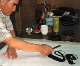 Каллиграф наносит иероглифы на рисовую бумагу