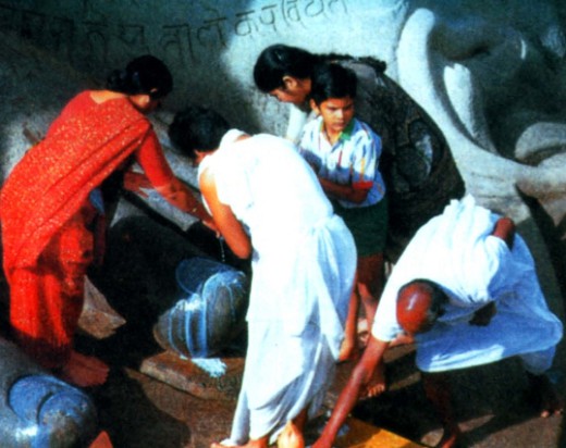 Почитатели омывают ступни ног статуи одного из Тирт-ханкаров