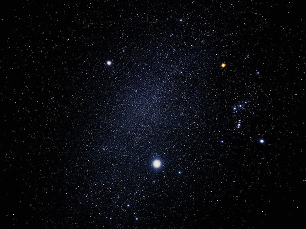 Сириус (самая яркая звезда), Процион (выше и левее) и созвездие Ориона (справа). Между Сириусом и Проционом хорошо виден участок Млечного Пути