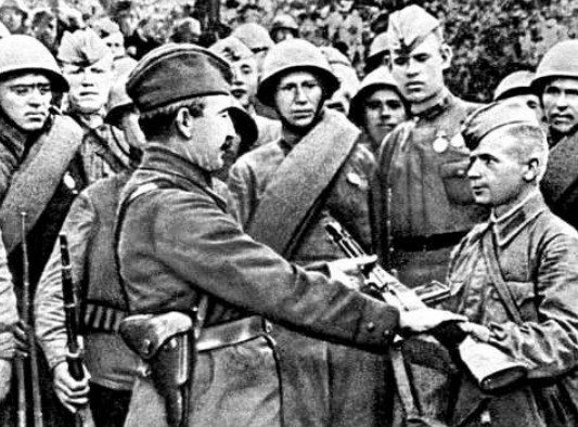 Генерал-лейтенант П.А. Белов вручает оружие снайперу Комарецкому, 1941 г.