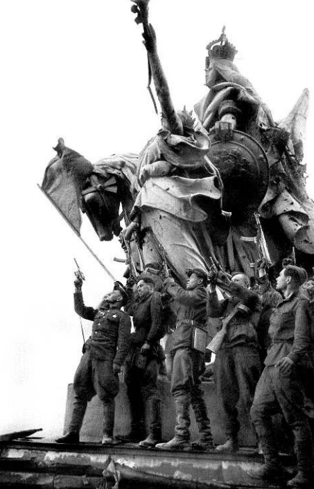 Фотография И. Шагина 1 мая 1945 г. «Салют в честь Победы на крыше Рейхстага. Солдаты батальона С. Неустроева»