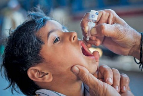 Медицинский работник дает полиовакцину ребенку из Карачи (Южный Пакистан)
