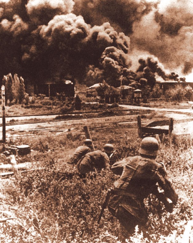 Немецкие солдаты приближаются к горящему нефтехранилищу в районе Майкопа