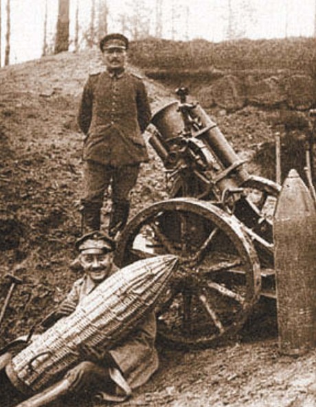 Немецкий артиллерист держит на коленях 250-мм снаряд к миномету SMW o6p. 1910 г. в чехле, сплетенном из прутьев