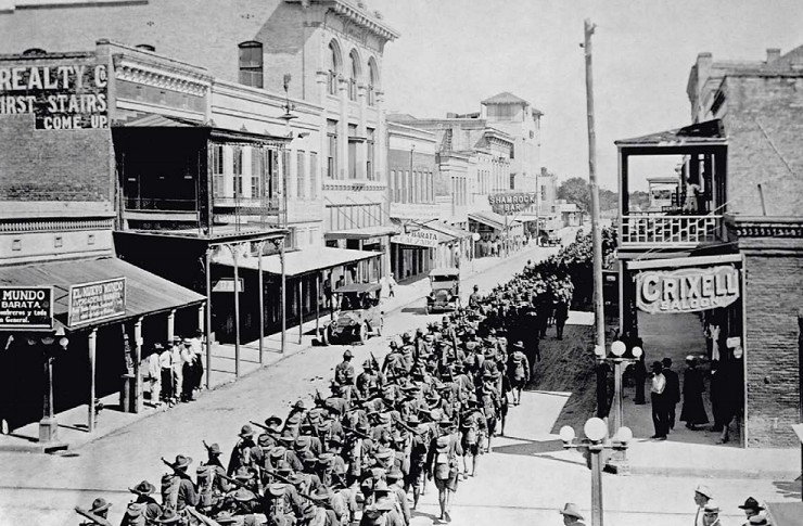Местные жители наблюдают за маршем американской 4-й пехотной дивизии по улицам города Браунсвилл, штат Техас