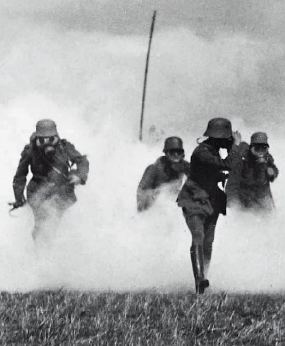 Бойцы немецкого штурмового батальона во главе с офицером появляются из облака отравляющего газа фосген во время штурма британской линии обороны