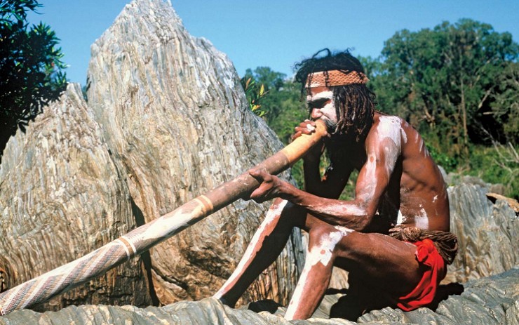 Австралийский абориген играет на традиционном музыкальном инструменте диджериду, который считается одним из старейших в мире