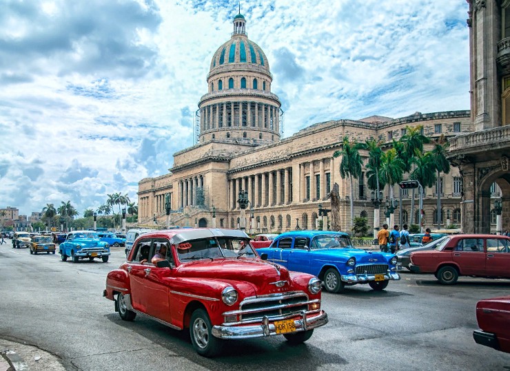 Старые классические американские автомобили проезжают перед Капитолием. Гавана, Куба