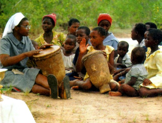 Монахини и дети стучат в барабаны в христианской школе в Зимбабве