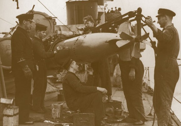 Британские матросы заряжают пусковую установку торпедой